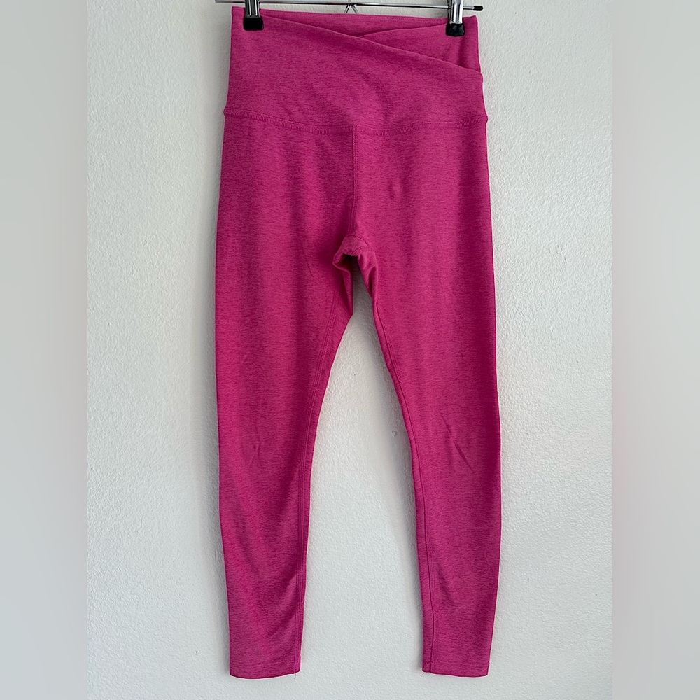 Beyond Yoga Pink Leggings with Crisscross waistband in front of